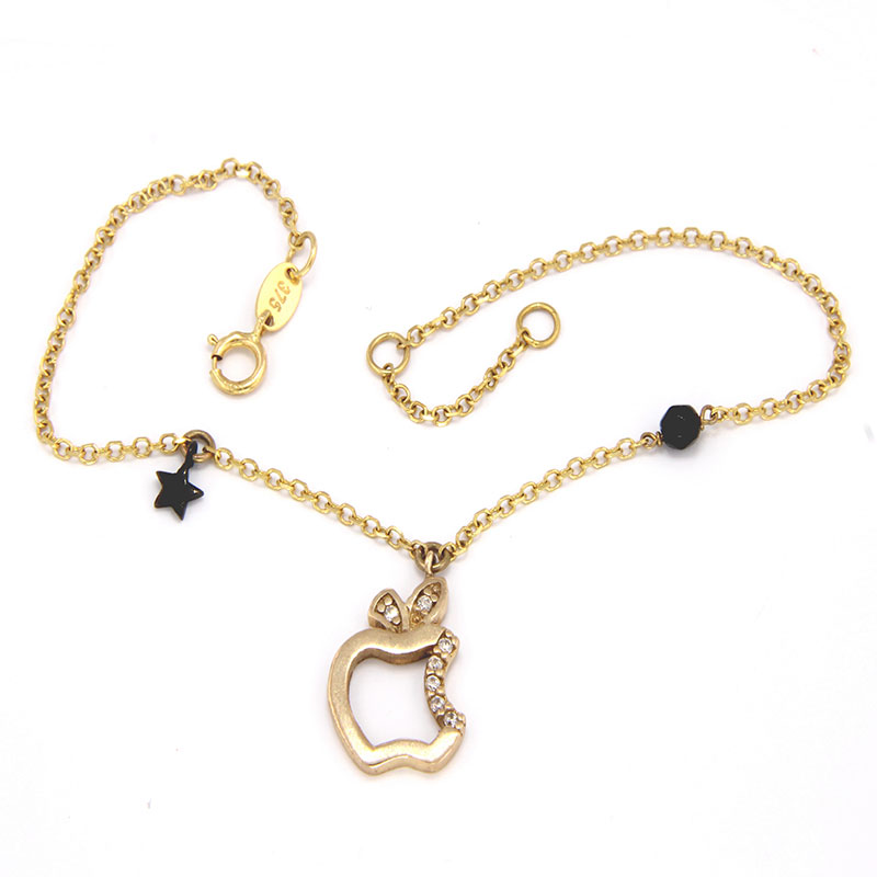 Womens gold bracelet K9 with apple-shaped motif decorated with a black platinum star, white zircons and black onyx.