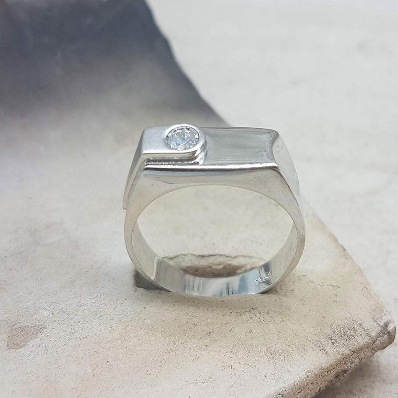 Aνδρικό δαχτυλίδι από λευκό χρυσό Κ14 με ειδική επεξεργασία διαμανταρίσματος και λευκό ζιργκόν. 