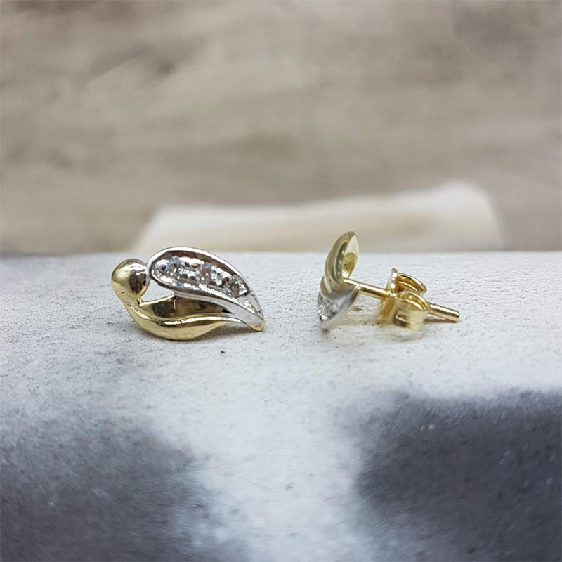 Γυναικεία χρυσά σκουλαρίκια Κ14 σε σχήμα φύλλου με λευκές λεπτομέρειες και λευκά ζιργκόν.