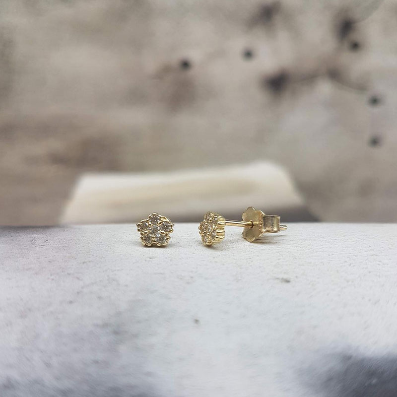 Παιδικά χρυσά σκουλαρίκια Κ14 σε σχήμα λουλούδι διακοσμημένα με λευκά ζιργκόν.